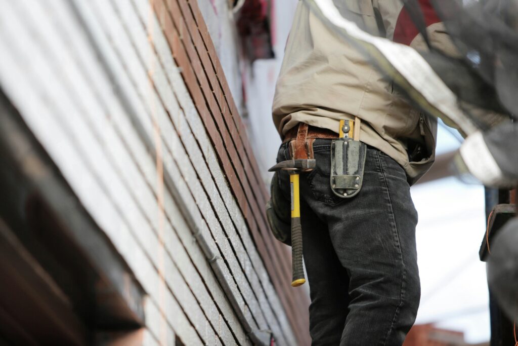 handy man fixing siding damage